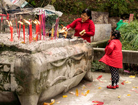 Woman honoring ancestors by burning "money", Mount Beishan