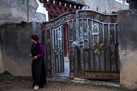 woman leaving her house through a typical gate